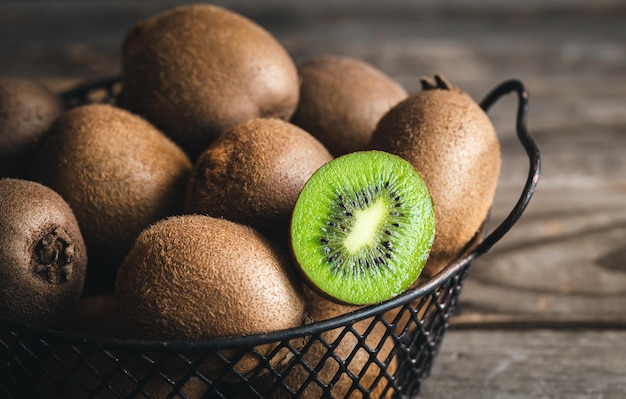 Zbliżenie cały kiwi i pół w metalowym koszyku makro- strzał