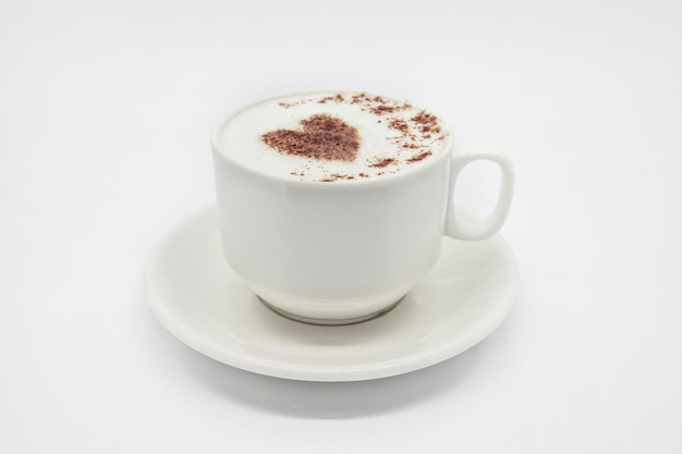 Zbliżenie cappuccino z pianką w kształcie serca na białym tle