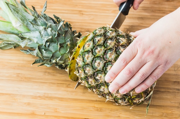 Zdjęcie zbliżenie cięcia ananasa na drewniane tła