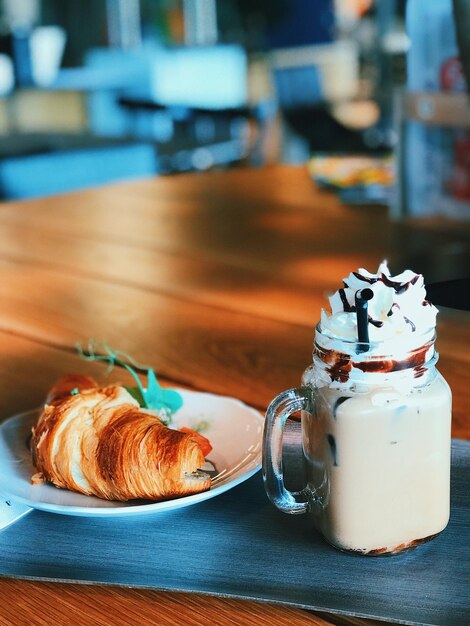 Zdjęcie zbliżenie croissant z lodową kawą podawaną na stole w restauracji