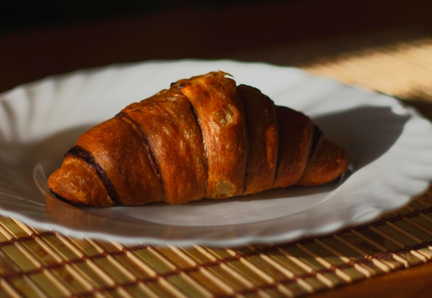 Zbliżenie croissanta na talerzu na stole