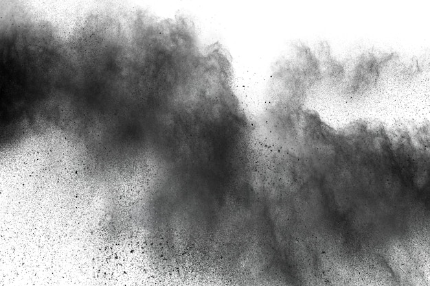 Zbliżenie czarne pył cząsteczki wybucha odosobnionego na białym tle.