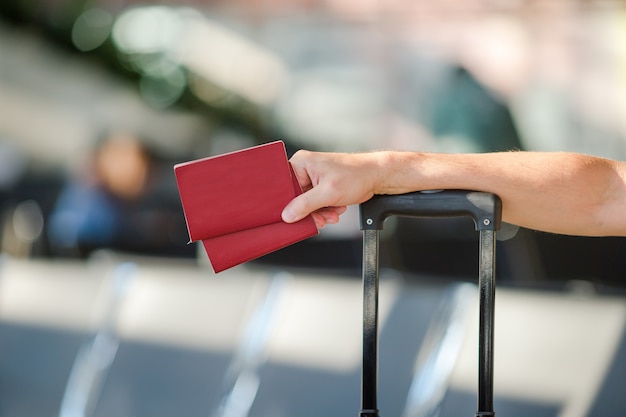 Zdjęcie zbliżenie człowiek posiadający paszporty i kartę pokładową na lotnisku