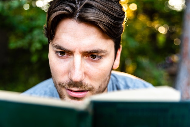 Zdjęcie zbliżenie człowieka czytającego książkę