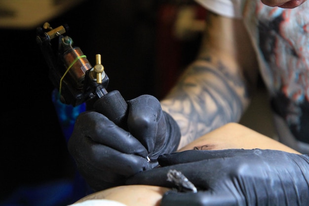 Zdjęcie zbliżenie człowieka robiącego tatuaż