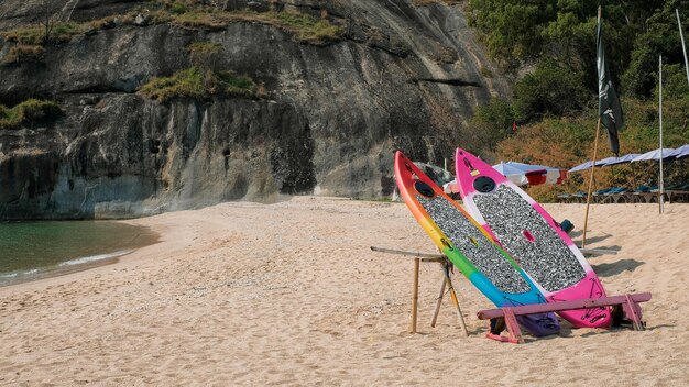 Zbliżenie deska surfingowa na plaży i tle gigantycznej skały