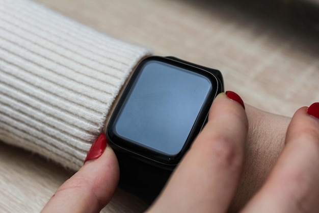 Zbliżenie dłoni biznesmena, która używa inteligentnego zegarka do przeglądania przychodzących wiadomości i połączeń do