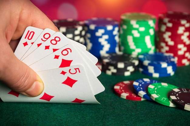 Zbliżenie dłoni gracza bierze karty do gry w klubie pokerowym Karty pokerowe z prostą kombinacją