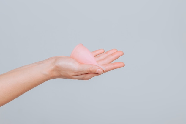 Zbliżenie dłoni kobiety trzymającej kubek menstruacyjny