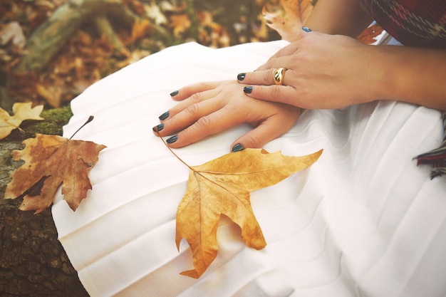 Zdjęcie zbliżenie dłoni kobiety z jesiennymi liśćmi