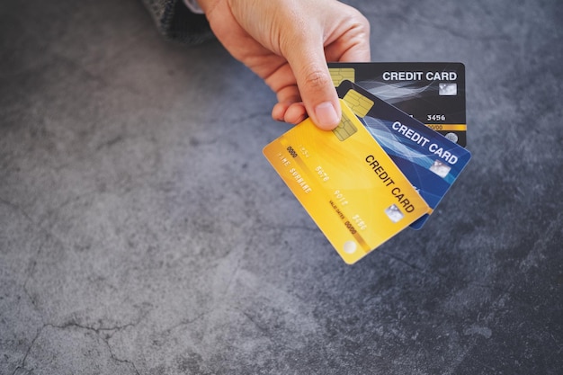 Zbliżenie dłoni trzymającej i pokazującej karty kredytowe