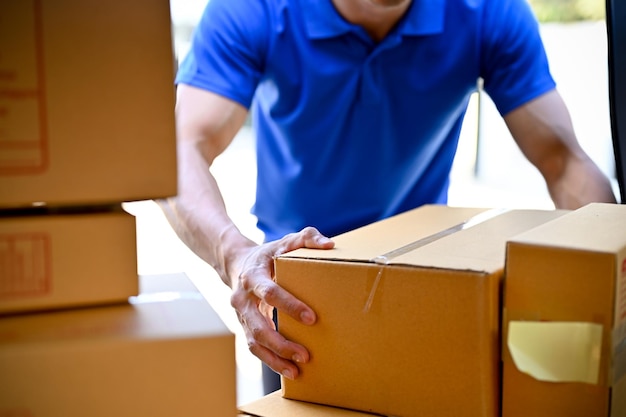 Zbliżenie dostawcy organizującego paczki przed przekazaniem paczki klientom