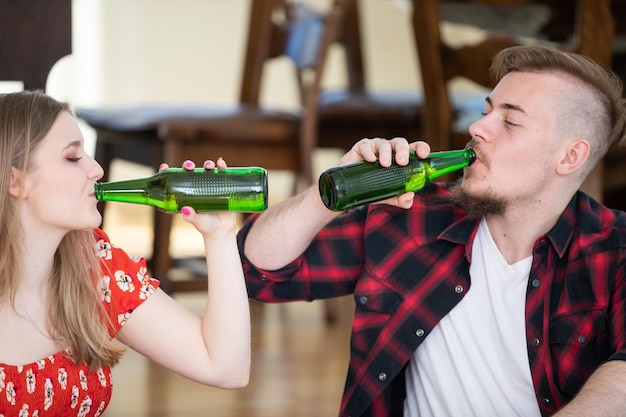 Zdjęcie zbliżenie dwóch osób pijących napoje ze szklanych butelek