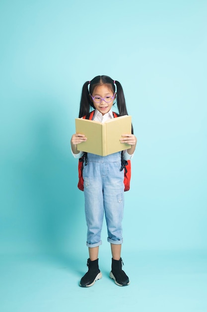 Zbliżenie dziecko studentów dziewczyna uśmiechający się trzymając książkę idzie do szkoły