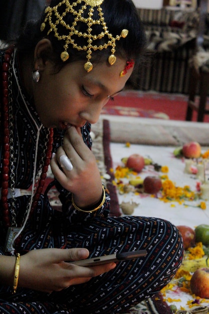 Zdjęcie zbliżenie dziewczyny w tradycyjnej sukience patrzącej na telefon komórkowy