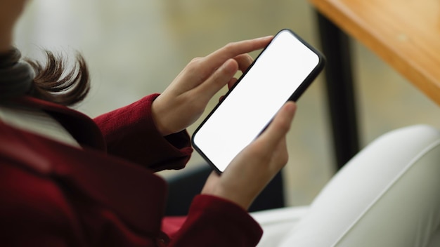 Zbliżenie Elegancka bizneswoman używa smartfona przy biurku do handlu zapasami makieta pustego ekranu