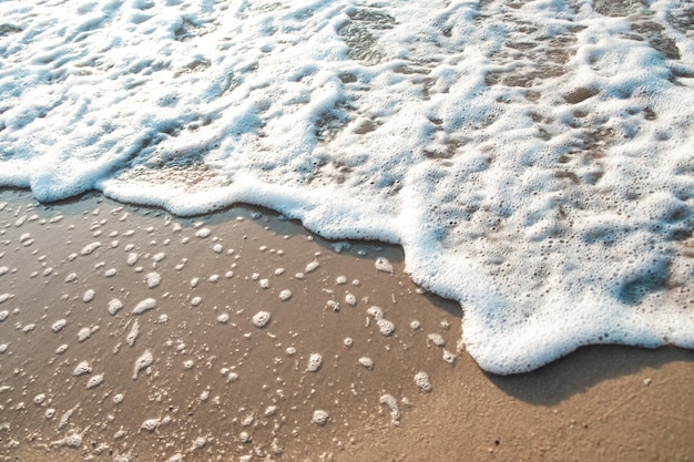 Zdjęcie zbliżenie fala piasek plaża morze piana zbliżenie fala morska z pianką na piasku plaży wakacje lato tło