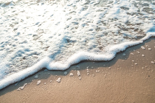 Zbliżenie fala piasek plaża morze piana zbliżenie fala morska z pianką na piasku plaży wakacje lato tło