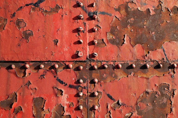 Zdjęcie zbliżenie farby odpadającej od metalowej ściany