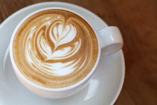 Zbliżenie filiżanka kawy latte na drewnianej selektywnej ostrości