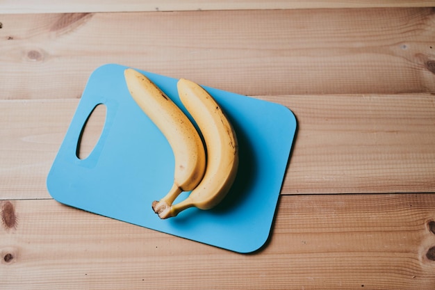 Zdjęcie zbliżenie garstki bananów na drewnianym tle kuchennego stołu