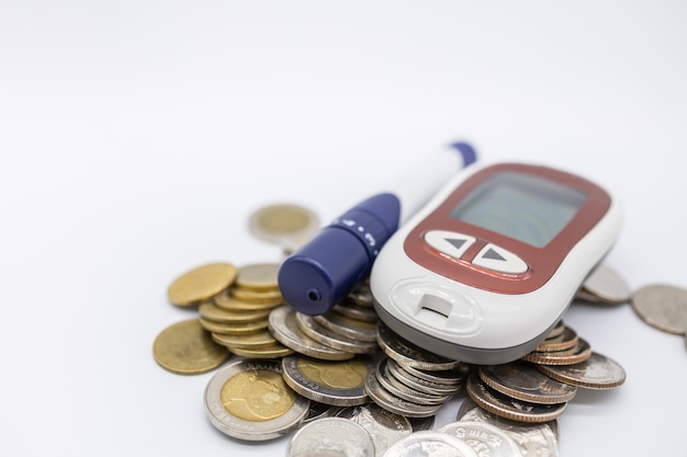 Zbliżenie Glukometru Z Lancetem Do Sprawdzania Poziomu Cukru We Krwi Na Stosie Monet.