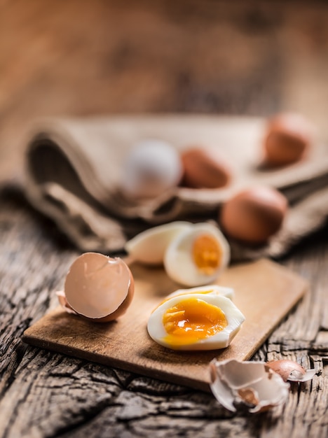 Zbliżenie gotowane lub surowe jaja kurze na desce.