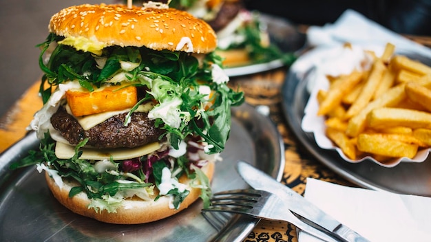 Zbliżenie hamburgera i frytek na stole