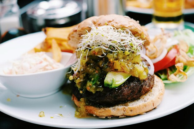 Zdjęcie zbliżenie hamburgera i sałatki na talerzu