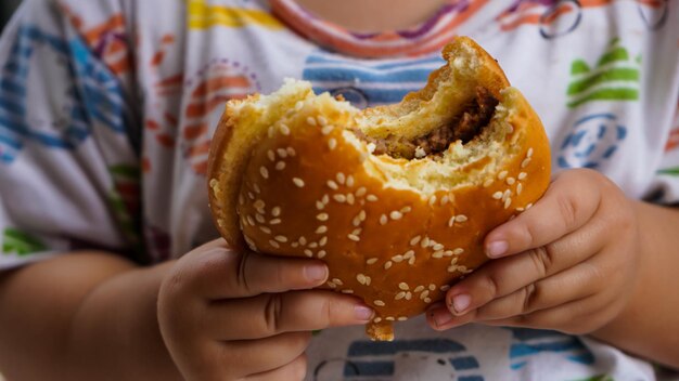 Zdjęcie zbliżenie hamburgera w ręku