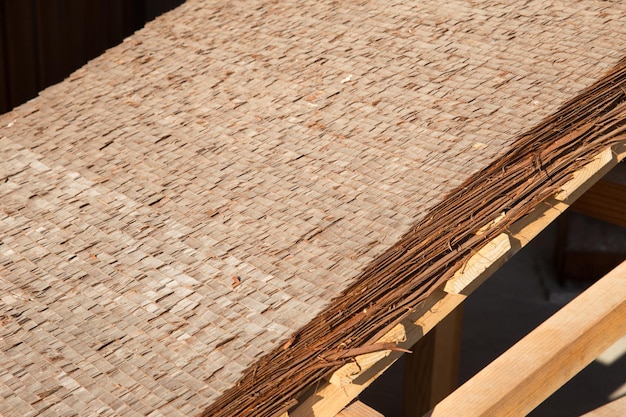 Zbliżenie Hiwada buki, tradycyjny japoński styl pokrycia dachowego, wykonany z warstw kory cedrowej lub cyprysowej, pokryty strzechą
