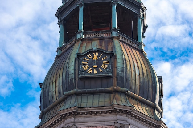 Zdjęcie zbliżenie iglicy z zegarem kościoła św piotra, stare miasto w rydze, łotwa
