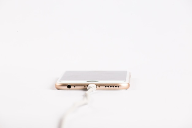 Zdjęcie zbliżenie kabla usb podłączonego do smartfona na białym tle