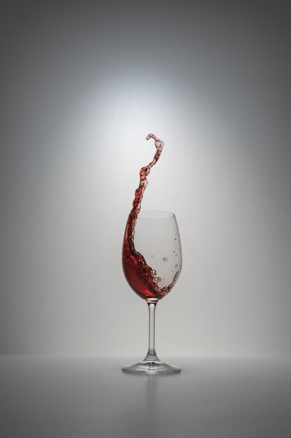 Zdjęcie zbliżenie kieliszka wina na stole na białym tle