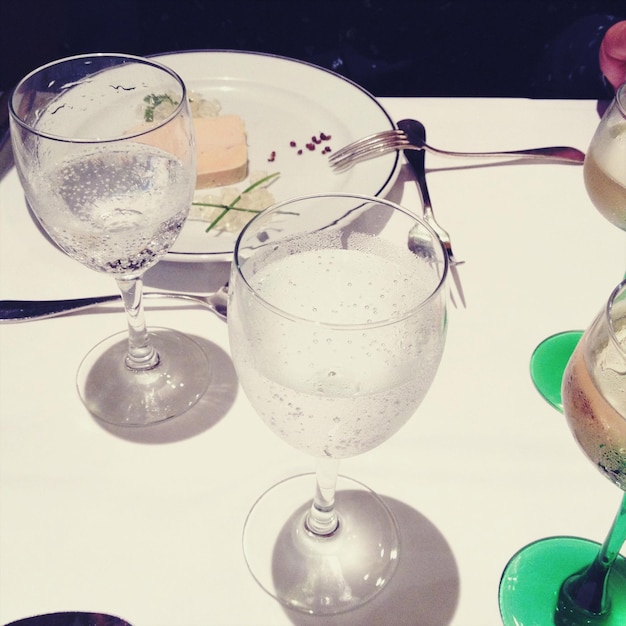 Zdjęcie zbliżenie kieliszków z jedzeniem i winem na stole jadalnym