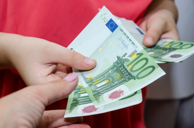 Zdjęcie zbliżenie kobiece ręce z pieniędzmi koncepcja dawania lub brania euro