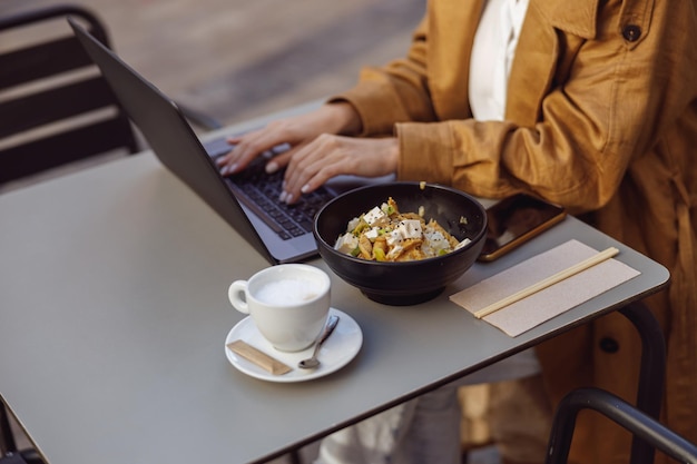 Zbliżenie kobiecej ręki wpisując coś na laptopie