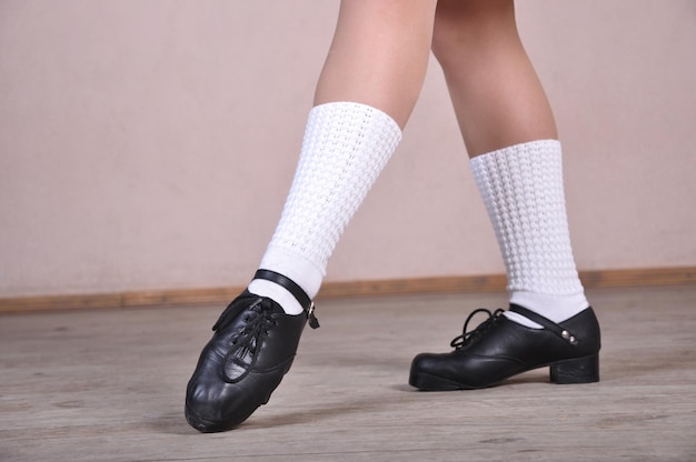 Zbliżenie kobiecych nóg w czarnych skórzanych butach tańczących narodowe tańce irlandzkie
