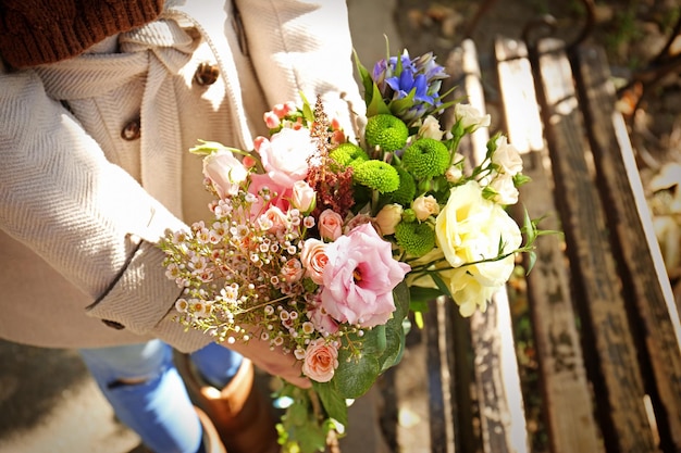 Zbliżenie kobiecych rąk trzymając stylowy bukiet pięknych kwiatów
