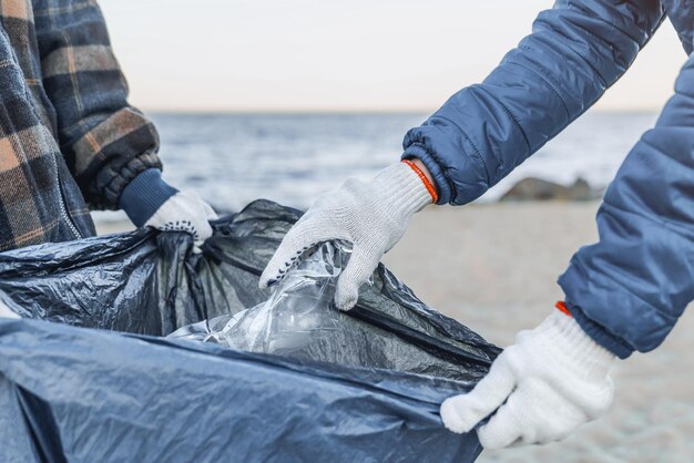 Zbliżenie Kobiet Zbiera Plastikowe śmieci W Worku Na śmieci Na Plaży Morskiej