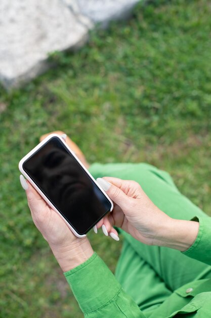 Zbliżenie: Kobieta Trzyma Telefon Komórkowy. Ekran Smartfona Z Odbiciem Osoby Na Nim. Koncepcja Technologii