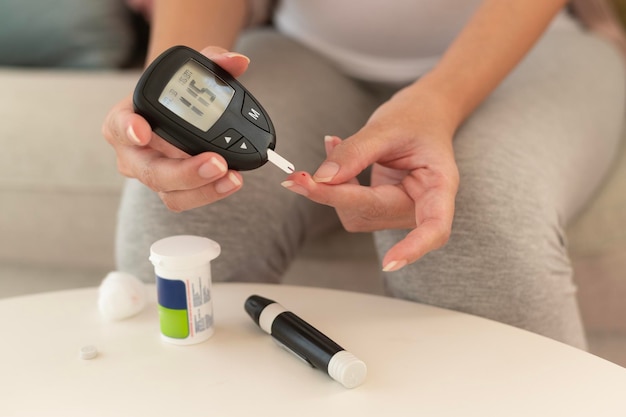 Zbliżenie kobiety kontrolującej poziom cukru we krwi za pomocą cyfrowego miernika glukozy