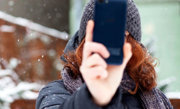 Zdjęcie zbliżenie kobiety robiącej selfie przez telefon komórkowy w zimie