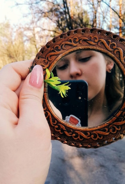 Zdjęcie zbliżenie kobiety robiącej selfie z lustrem w ręku