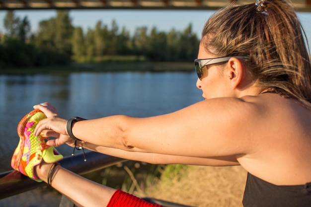 Zdjęcie zbliżenie kobiety-sportowca rozciągającej mięśnie. sportowa młoda kobieta. bieganie