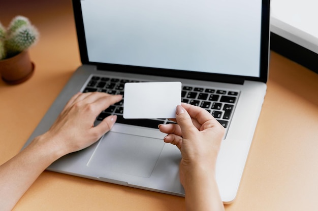 Zbliżenie kobiety trzymającej kartę kredytową i używającej laptopa