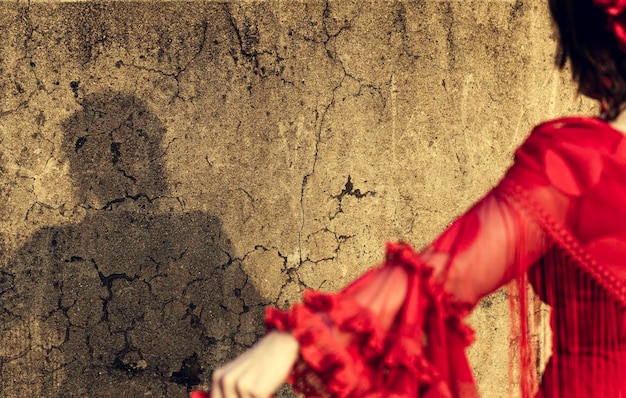 Zdjęcie zbliżenie kobiety w czerwonej sukience na ścianie