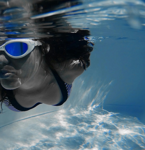 Zbliżenie kobiety w okularach pływającej w basenie