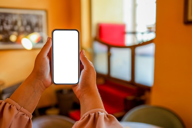 Zbliżenie kobiety za pomocą telefonów komórkowychwysyłanie masaży w kawiarni