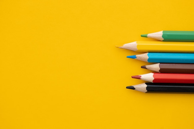Zbliżenie kolorowy ołówek na żółtym tle z powrotem do koncepcji szkoły